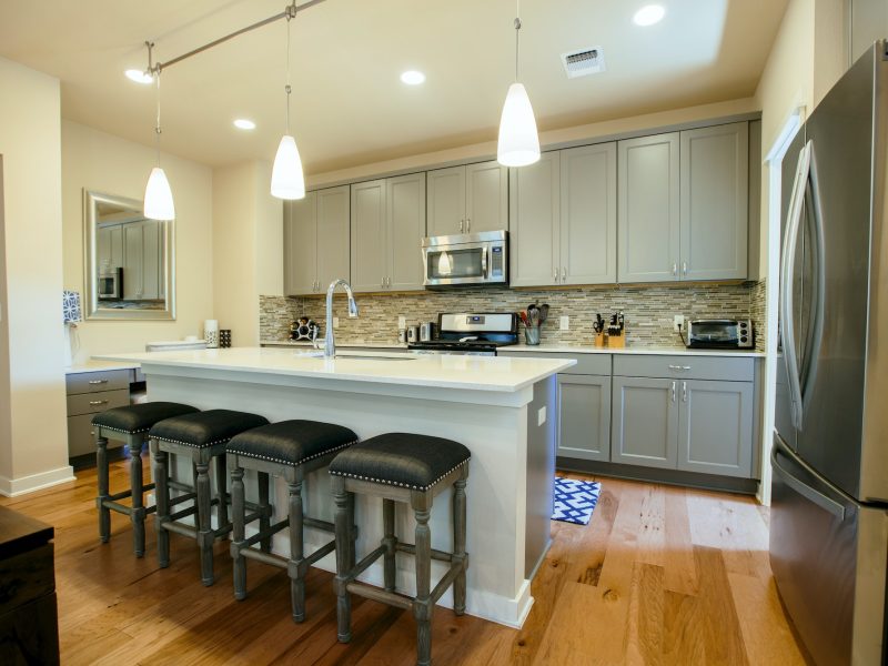 Modern home kitchen with green grey fitted units and kitchen island